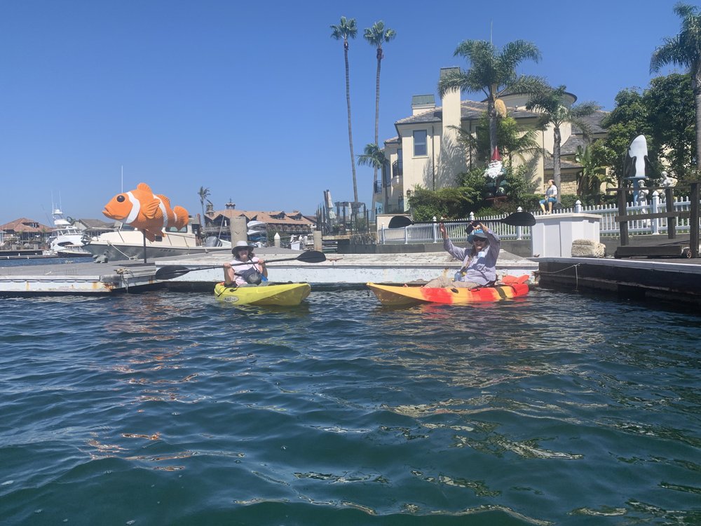Kayaker passing whimsical dock decorations